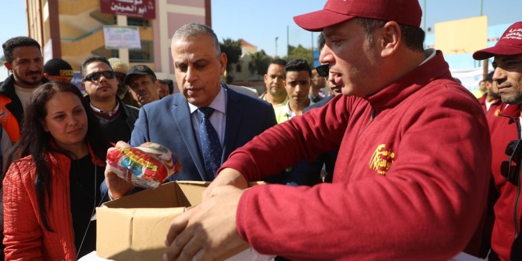 اللواء طارق الفقى محافظ اسيوط يستعرض كرتونة المواد الغذائية فى قافلة ستر وعافية