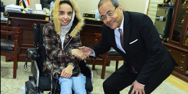جامعة سوهاج تهدي طالبة من ذوي الاحتياجات الخاصة كرسي متحرك كهربائي